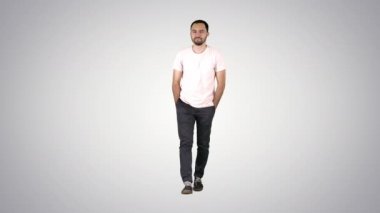 İleri yürüyüş ve üzerinde gradyan arka planı gradyan gömlek kamerada bakarak kendine güvenen genç yetişkin adam.