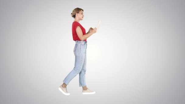 Mulher feliz andando com tablet no fundo gradiente. — Vídeo de Stock