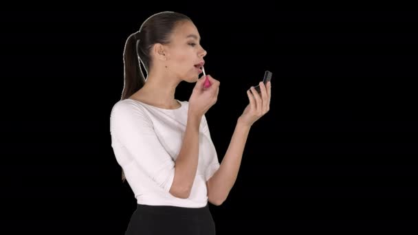 Hermosa mujer, se tiñe los labios de lápiz labial de color rosa, mirando en el espejo, Alpha Channel — Vídeo de stock