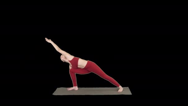 Mujer joven practicando yoga, termina haciendo ejercicio Utthita parsvakonasana, Alpha Channel — Vídeos de Stock