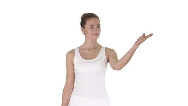 Γυναίκα σε κενή λευκή δεξαμενή πάνω περπάτημα και δείχνοντας σε κάτι στο πλάι σε λευκό φόντο. — Αρχείο Βίντεο