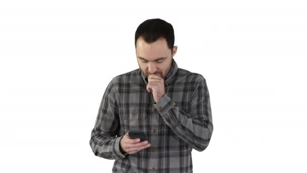 Joven triste caminando y mirando su teléfono móvil con la mano en la cara sobre fondo blanco . — Vídeos de Stock