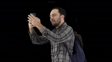 Sırt çantası taşıyan yakışıklı genç bir adam ve kendi fotoğrafını çekiyor, Alpha Channel.