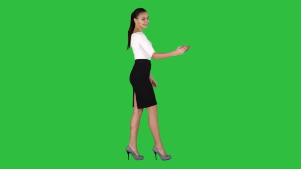 Joven morena tomando foto selfie en smartphone sonriendo alegre y caminando en una pantalla verde, Chroma Key . — Vídeo de stock