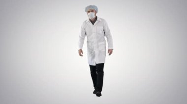 Yürüyen maske takmış genç bir erkek doktor ve arka planda tıbbi bir başlık..