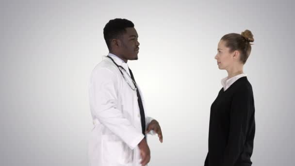 Врач-мужчина предлагает лекарства молодой женщине на градиентном фоне . — стоковое видео