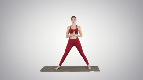 Jovem yogi mulher atraente praticando conceito de ioga, de pé em Utthita parsvakonasana exercício no fundo gradiente . — Vídeo de Stock