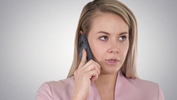 Glimlachende vrouw praten aan de telefoon op gradiënt achtergrond. — Stockvideo