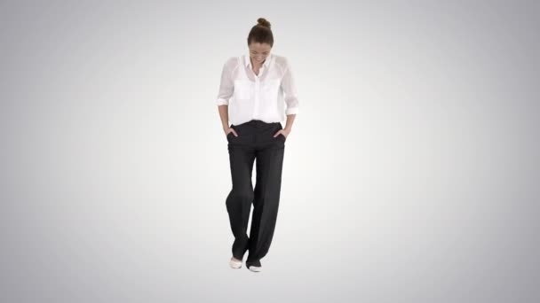 Femme d'affaires marchant avec les mains dans les poches et riant sur fond de dégradé . — Video