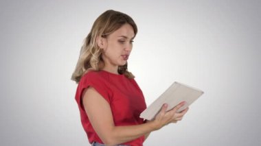 Kırmızı tişörtlü kadın gradyan arkaplanda tablet kullanıyor.