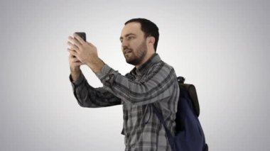 Sırt çantası taşıyan ve degrade arka plan üzerinde kendini bir resim çekmek yakışıklı delikanlı.