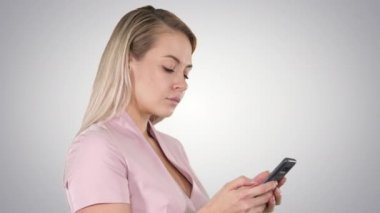 Degrade arka plan üzerinde smartphone cep telefonu ile mesaj gönderme neşeli genç kadın portresi.