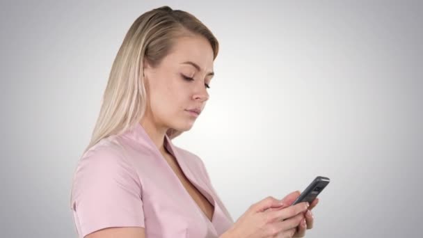 愉快的年轻妇女的画像在智能手机上发送消息在梯度背景. — 图库视频影像