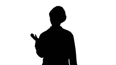 Siluet olgun mühendisi kadın konuşmak ve taraf işaret eden bir şey sunmak zor şapka ve laboratuvar ceket.