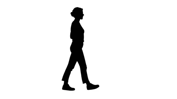 シルエット フィット女の子歩いて白いジーンズのポケットに彼女の手を保持しています。. — ストック写真
