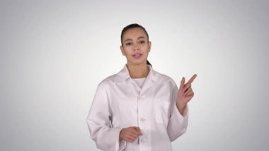 Çekici doktor yan tarafı işaret ediyor. Eğim arkaplanı üzerine ürün sunuyor..