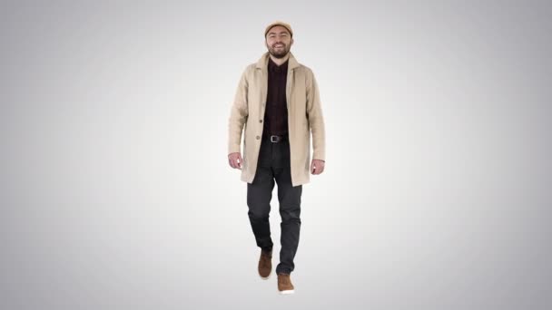 Knappe man in modieuze kleding lopen en glimlachen op verloop achtergrond. — Stockvideo