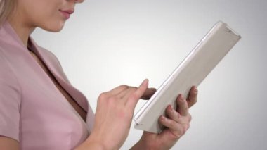 Gradyan arkaplanda tablet kullanan kadın elleri.