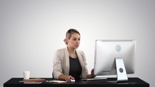 Belle femme blonde travaillant sur ordinateur sur fond de dégradé . — Video