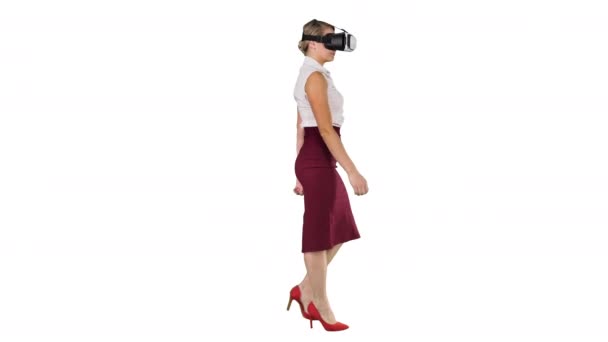 Jeune femme portant un appareil de réalité virtuelle et marchant sur fond blanc . — Video