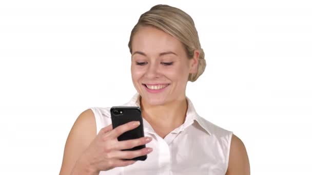 Gelukkig mooie jongedame glimlachend en het gebruik van mobiele telefoon op witte achtergrond. — Stockvideo