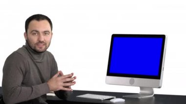 Gülümseyen ve bir şey bilgisayar, beyaz arka plan monitörde gösterilen kameraya konuşurken rahat iş adamı. Mavi ekran Mock-up.