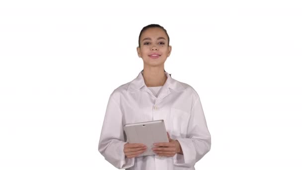 Feliz médico femenino usando la tableta de la computadora deslizando páginas en él sobre fondo blanco . — Vídeo de stock