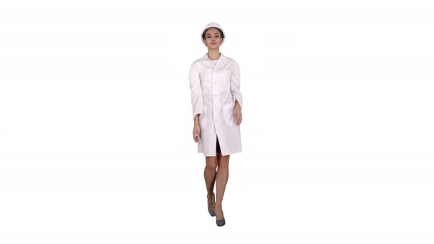 Woman engineer in white robe and white hard hat walking on white background. — Stock Video