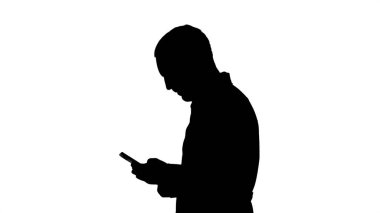 Siluet yürüyen doktor ya da hemşire cep telefonundan mesaj atıyor..