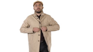 Soğuk hava Sonbahar ya da Kış Günü Çukurdaki Adam beyaz arka planda düğmelerini ilikliyor.