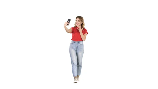 Linda chica sexy con cabello rubio rizado caminando y haciendo selfie sobre fondo blanco . —  Fotos de Stock