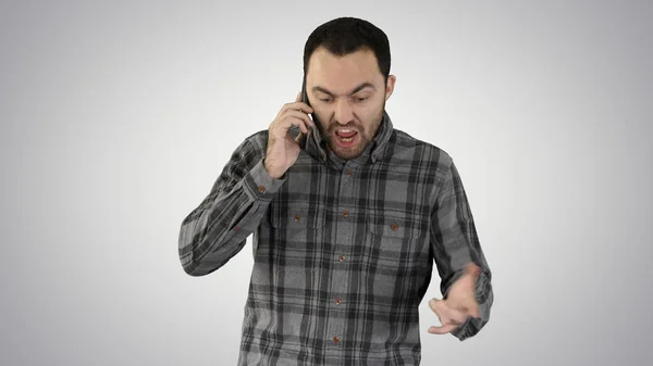 Man angry talking on telephone and walking on gradient background. — Stock Photo, Image