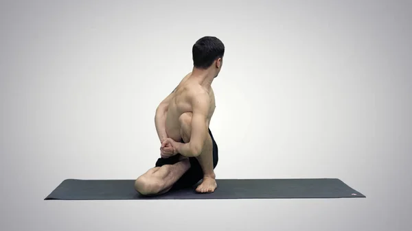 Adam pratik yoga adaçayı Twist C poz veya Marichyasana poz yoga meditasyon ile egzersiz kas germe rahatla ve sağlığı üzerindeki degrade arka plan yenileme. — Stok fotoğraf