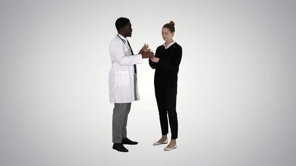 Αρσενικό γιατρός προσφέρει τη φαρμακευτική αγωγή σε νεαρή γυναίκα σε φόντο κλίση. — Φωτογραφία Αρχείου