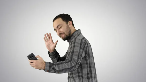 Young man taking selfie picture with smart-phone on gradient background. — Stock Photo, Image