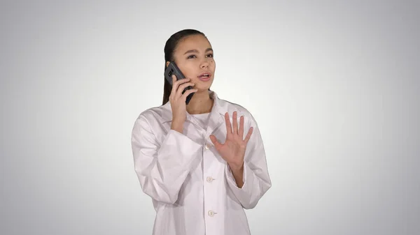 Doctora confiada, profesional de la salud hablando por teléfono con el paciente sobre el fondo del gradiente . — Foto de Stock