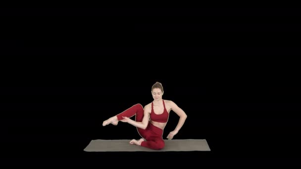 Sporty yogi girl doing fitness practice, stretches, yoga asana Parivritta Kraunchasana, Alpha Channel — Stock Video