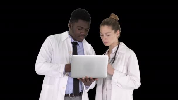 Медицинский персонал, стоящий перед серым ноутбуком, Альфа-канал — стоковое видео