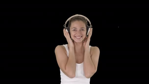Mulher com fones de ouvido ouvindo música e fazendo cara engraçada, Alpha Channel — Vídeo de Stock