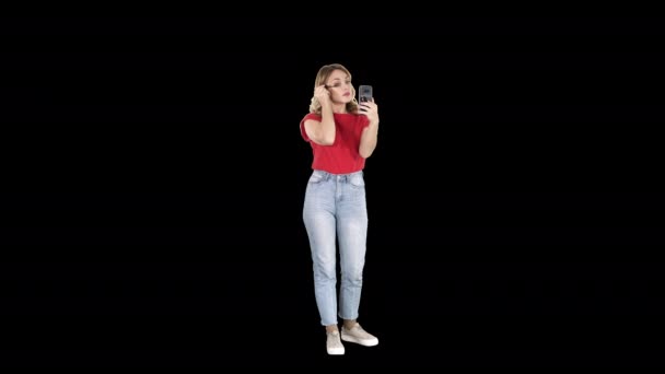 Belle jeune femme utilisant le mascara et regardant dans son smartphone, Alpha Channel — Video