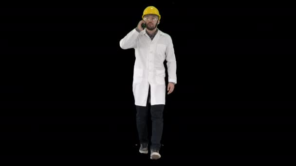電話にヘルメットをかぶっている自信のある男性エンジニア, Alpha Channel — ストック動画