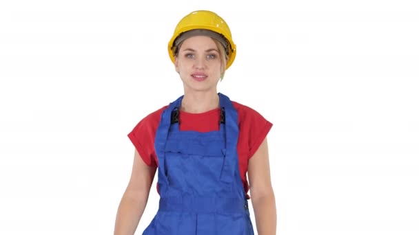 Mladá žena ve žlutém hardhat chůze na bílém pozadí. — Stock video