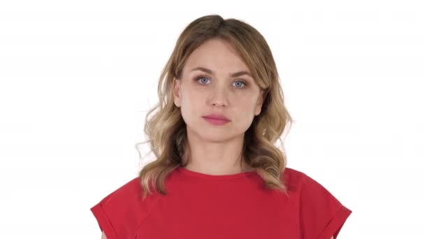 Mujer joven camiseta roja está caminando, mirando a la cámara en el fondo blanco . — Vídeos de Stock