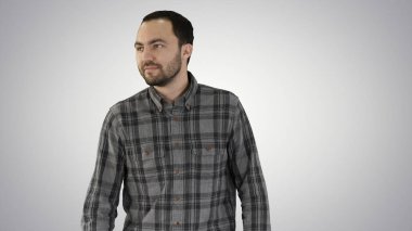 Büyüleyici başarılı genç girişimci yürüyüş ve taraf için degrade arka plan üzerinde arıyor.