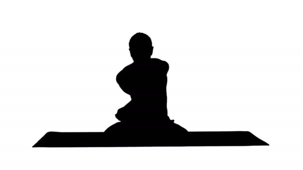 Silhouet Sportieve mooie jonge man die yoga beoefent, zittend met gekruiste benen in Adho Mukha Padmasana, voorover buigend in variatie op Lotus Pose. — Stockvideo