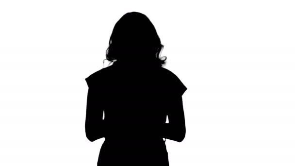 Silhouette Fiatal gyönyörű nő pólóban használja az okostelefonját. — Stock videók