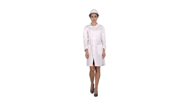 Mulher engenheira em roupão branco e chapéu duro branco andando sobre fundo branco. — Fotografia de Stock