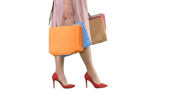 Rész test, gyönyörű nő karcsú lábak Sexy girl gazdaság egy könyv bevásárló táskák, fehér háttér. — Stock Fotó