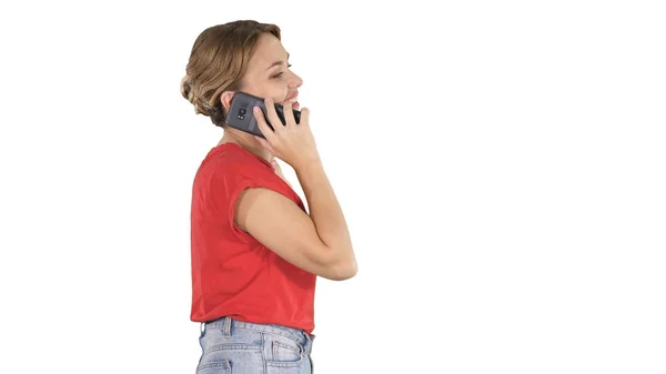 Blonde vrouw lopend en pratend aan de telefoon op witte achtergrond. — Stockfoto