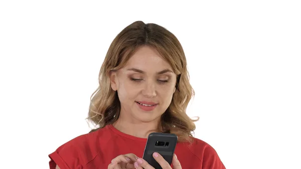 Denken hübsche Blondine sendet einen Text auf ihrem Handy auf weißem Hintergrund. — Stockfoto
